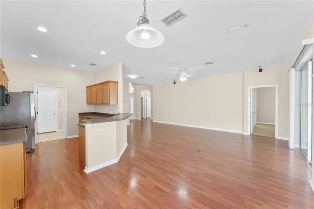 a view of kitchen with kitchen island wooden floor appliances and cabinets