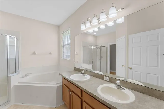 a bathroom with a granite countertop sink a large mirror and a bathtub