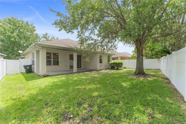 a view of a house with backyard and a tree