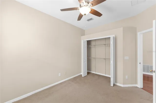 an empty room with closet and fan
