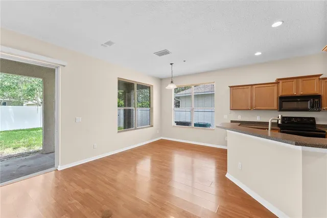 a large kitchen with stainless steel appliances granite countertop a large counter top and a wooden floor