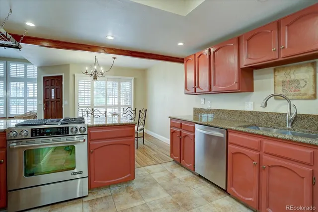 a kitchen with stainless steel appliances granite countertop wooden cabinets stove top oven and sink