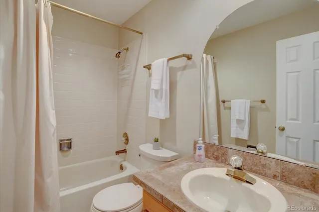 a bathroom with a granite countertop sink toilet tub and shower
