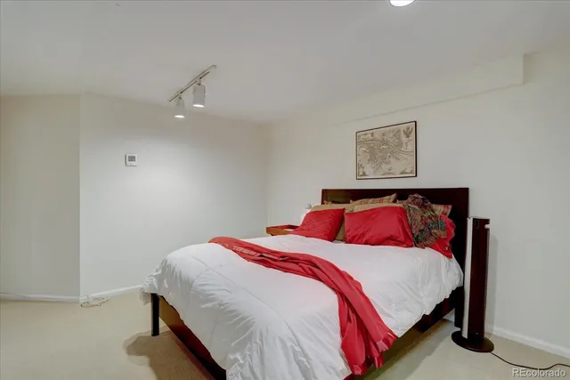 a bedroom with a bed and a painting on the wall