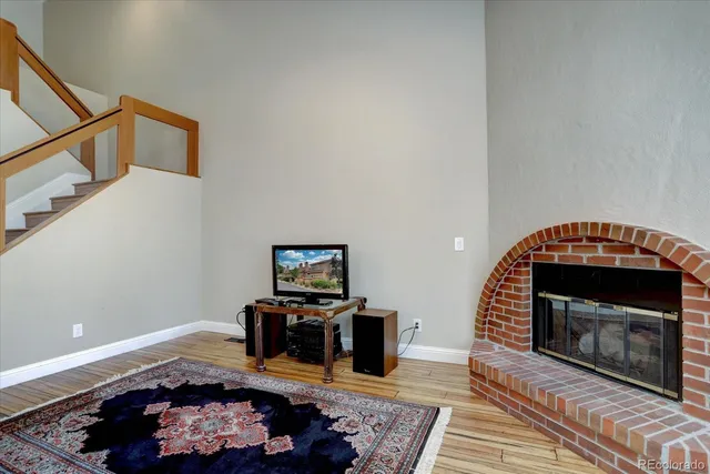 a living room with furniture a fireplace and a wooden floor