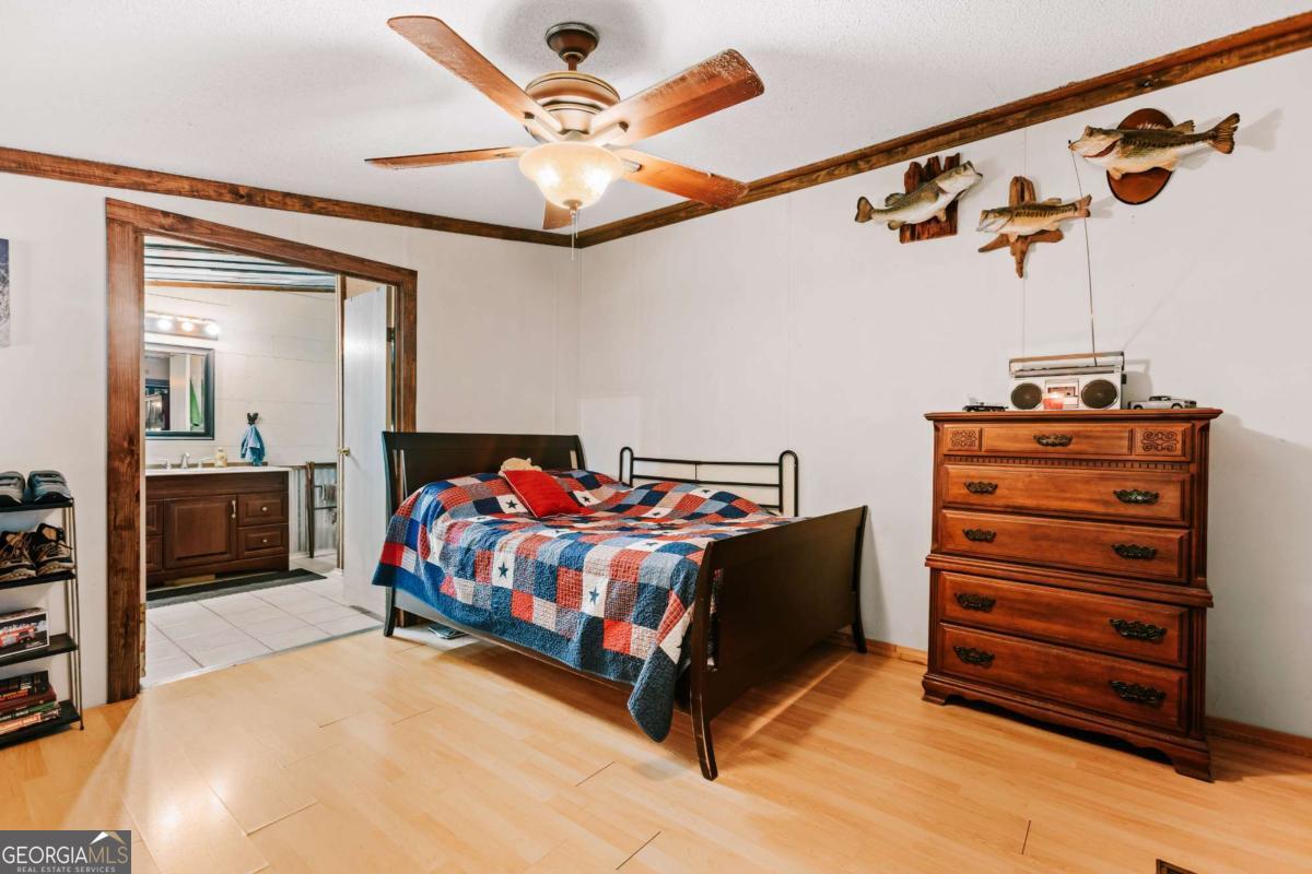 5971 Penfield Road Union Point, GA 30669 - Photo 15 of 42 a bed room with a bed and a chandelier