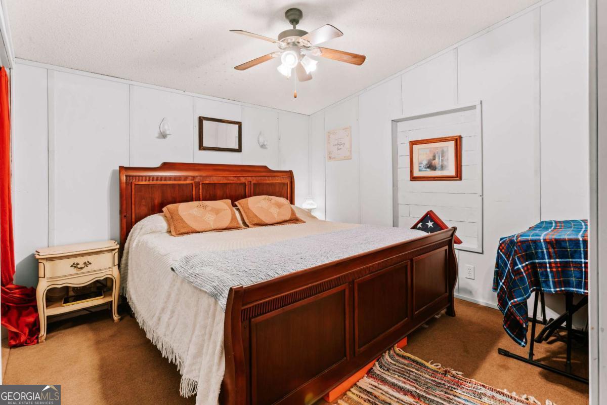 5971 Penfield Road Union Point, GA 30669 - Photo 21 of 42 a bedroom with a bed and a chandelier