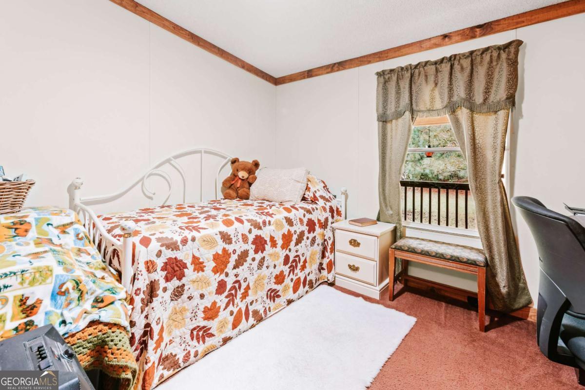 5971 Penfield Road Union Point, GA 30669 - Photo 24 of 42 a bedroom with a bed and a window