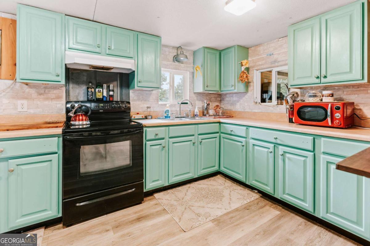 5971 Penfield Road Union Point, GA 30669 - Photo 32 of 42 a kitchen with stainless steel appliances a stove sink and cabinets