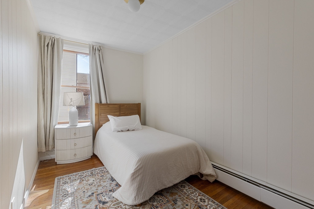 56 Spring Street, Unit 56 Cambridge, MA 02141 - Photo 11 of 15 a bedroom with a bed and wooden floor