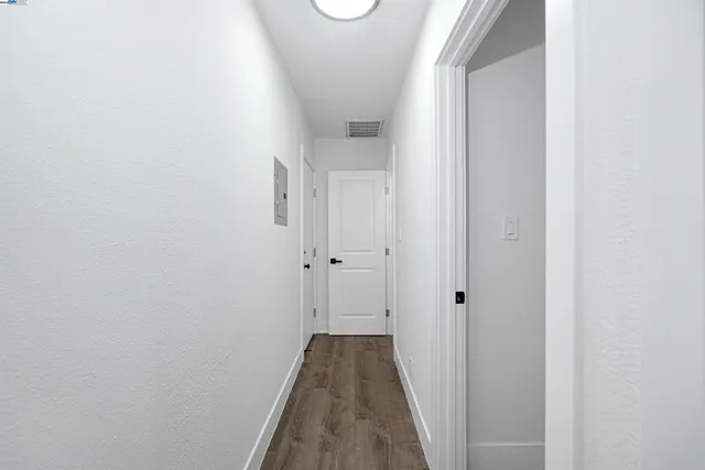 a view of a hallway with wooden floor and closet