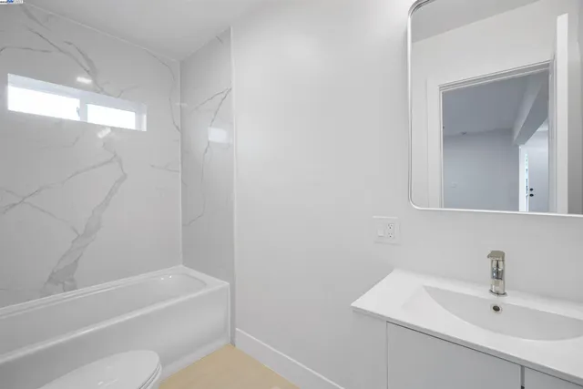 a bathroom with a bath tub a sink and a mirror