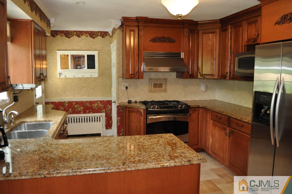 110 Stafford Road Colonia, NJ 07067 - Photo 14 of 24 a kitchen with stainless steel appliances granite countertop a stove a sink and a refrigerator