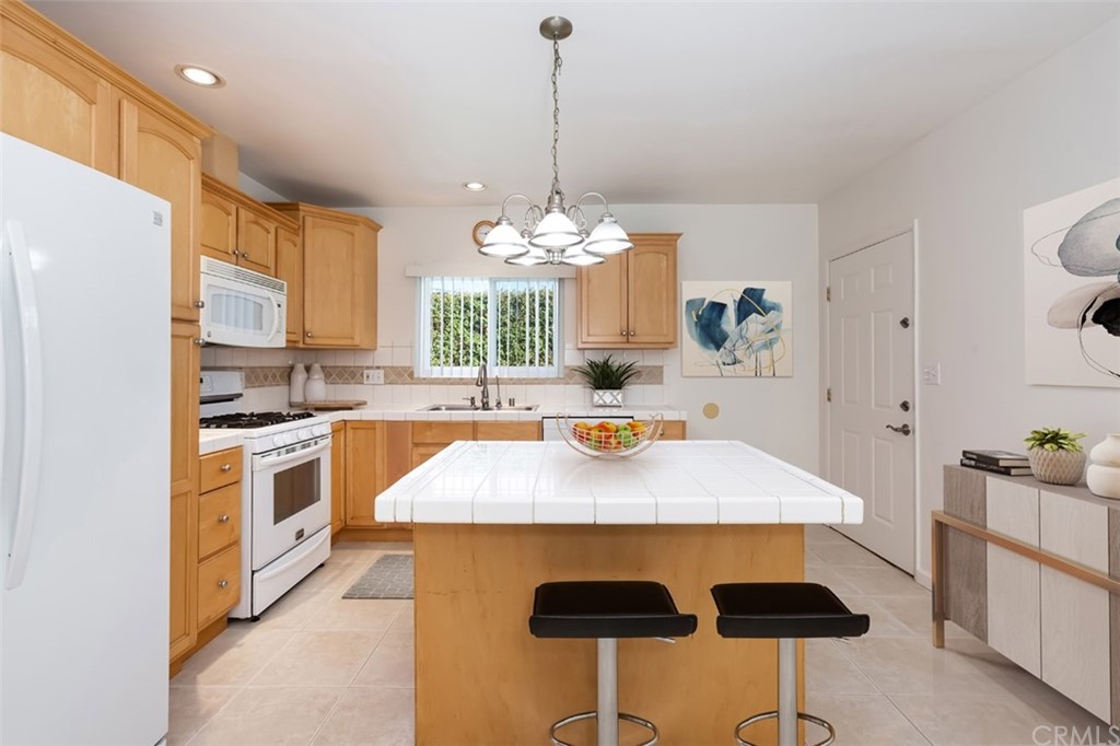 610 Del Monte Street Pasadena, CA 91103 - Photo 16 of 49 a kitchen with stainless steel appliances a table chairs and a refrigerator