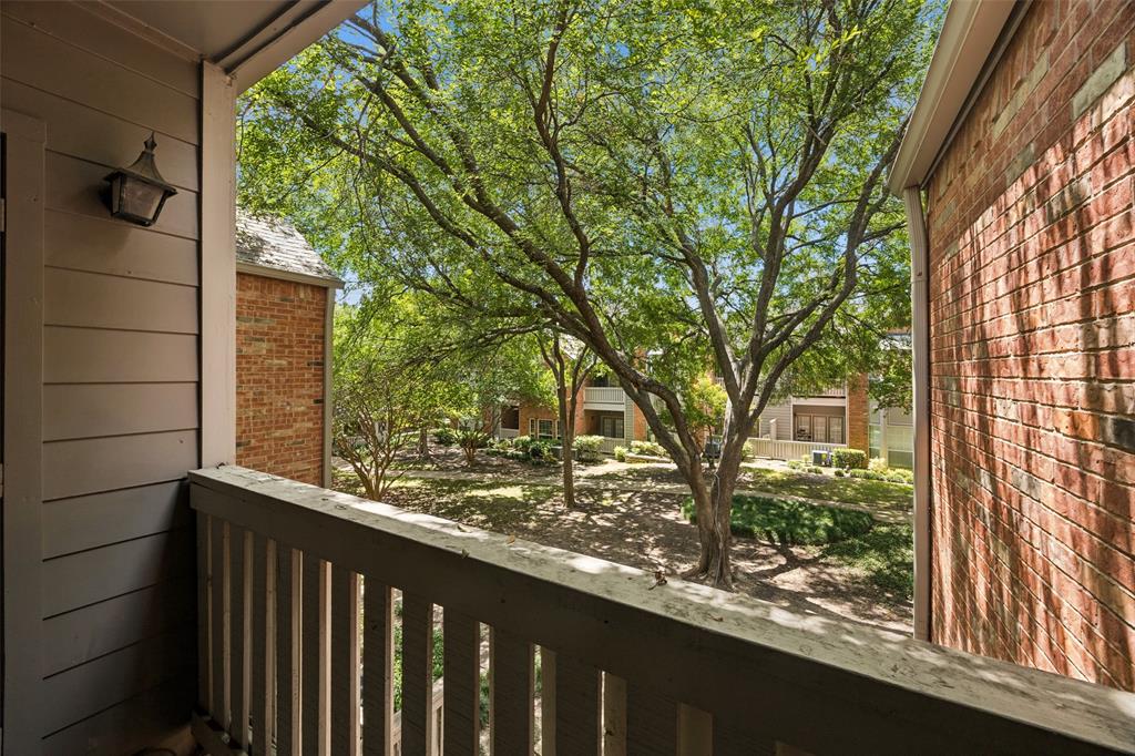 12660 Hillcrest Road, Unit 7205 Dallas, TX 75230 - Photo 16 of 25 Covered balcony featuring a wood railing and exterior wall sconce