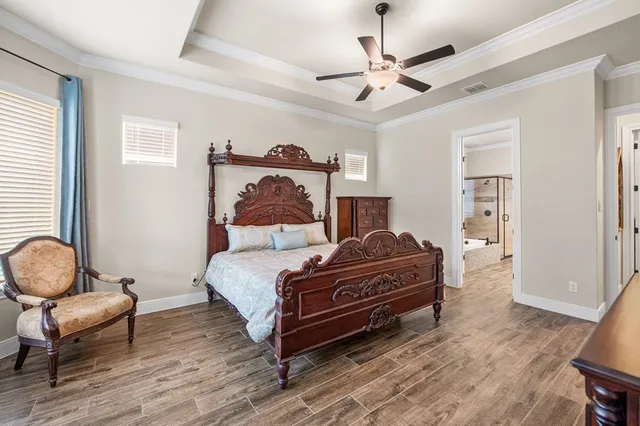 a bedroom with a large bed and a chandelier