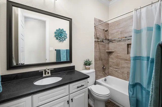 a backyard of a house with table and chairs under an umbrella