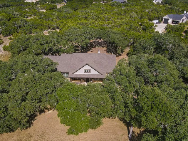 an aerial view of a house with a yard and lake view