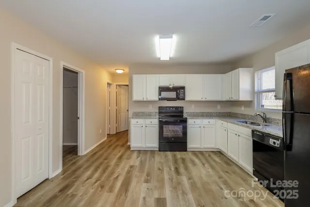 a kitchen with stainless steel appliances granite countertop a refrigerator and a stove top oven