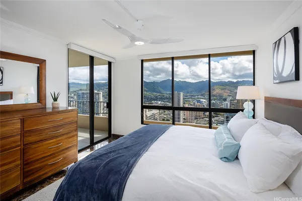 a bedroom with a bed and large windows