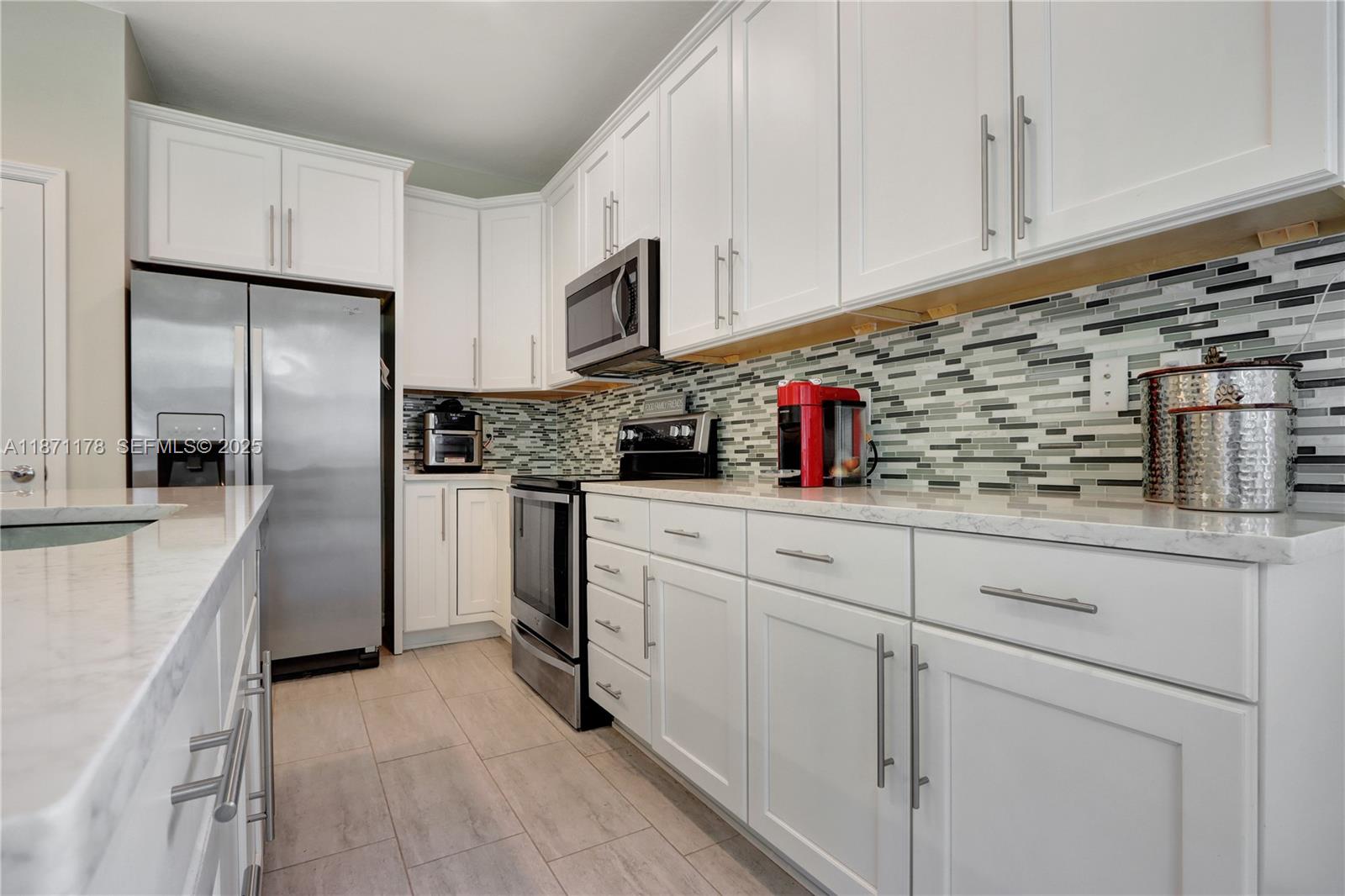 4353 Large Leaf Lane Hollywood, FL 33021 - Photo 11 of 31 a kitchen with white cabinets and refrigerator
