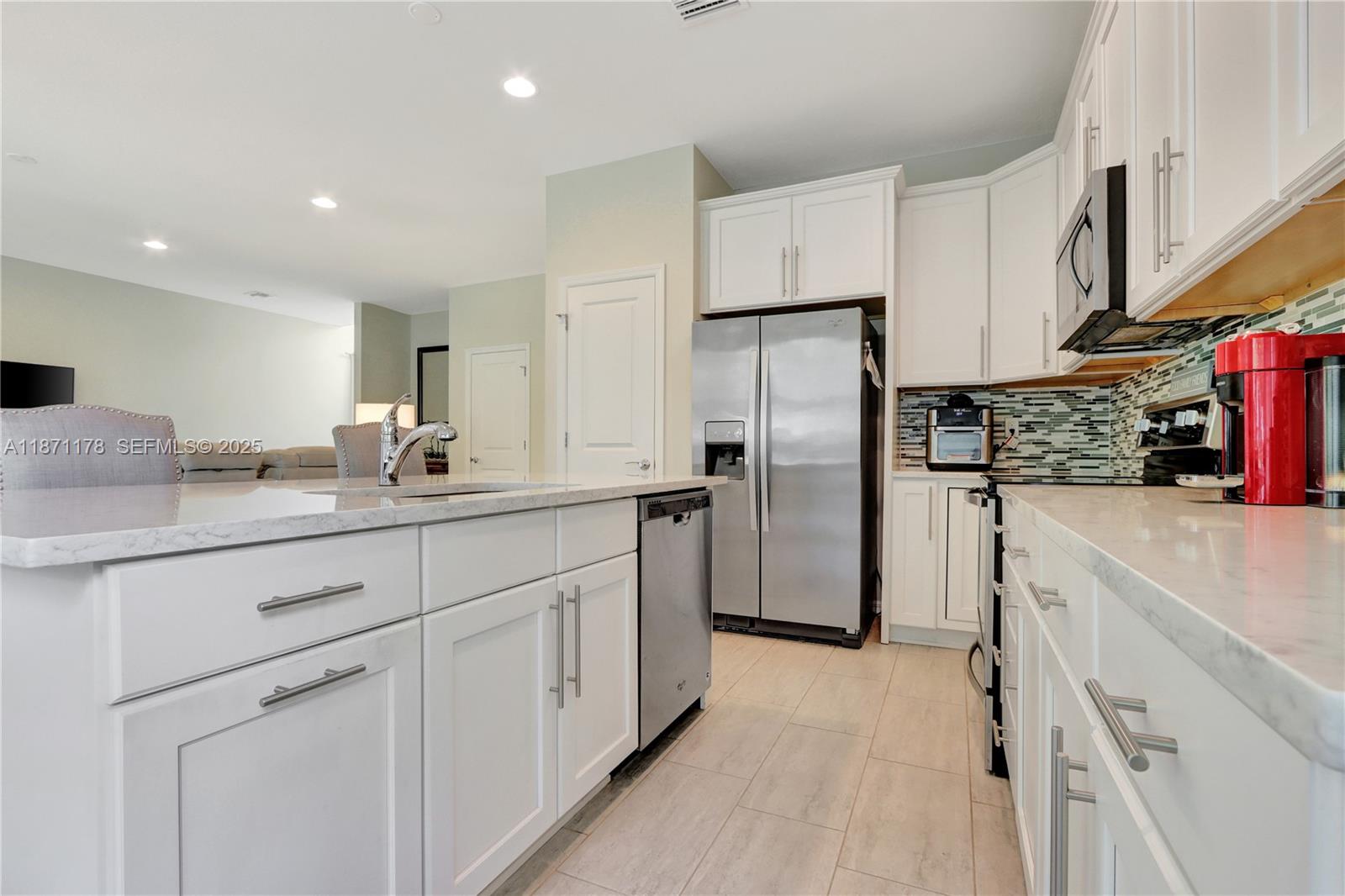 4353 Large Leaf Lane Hollywood, FL 33021 - Photo 10 of 31 a kitchen with stainless steel appliances a refrigerator sink and cabinets