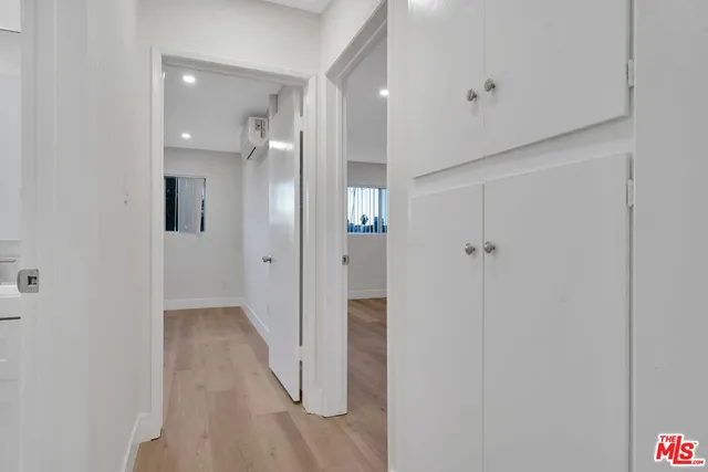 a view of a hallway with wooden shelves