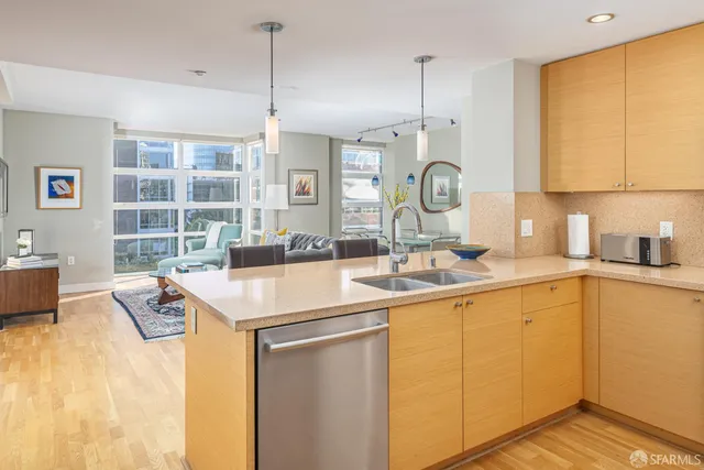 a kitchen with a sink a counter top space and living room area