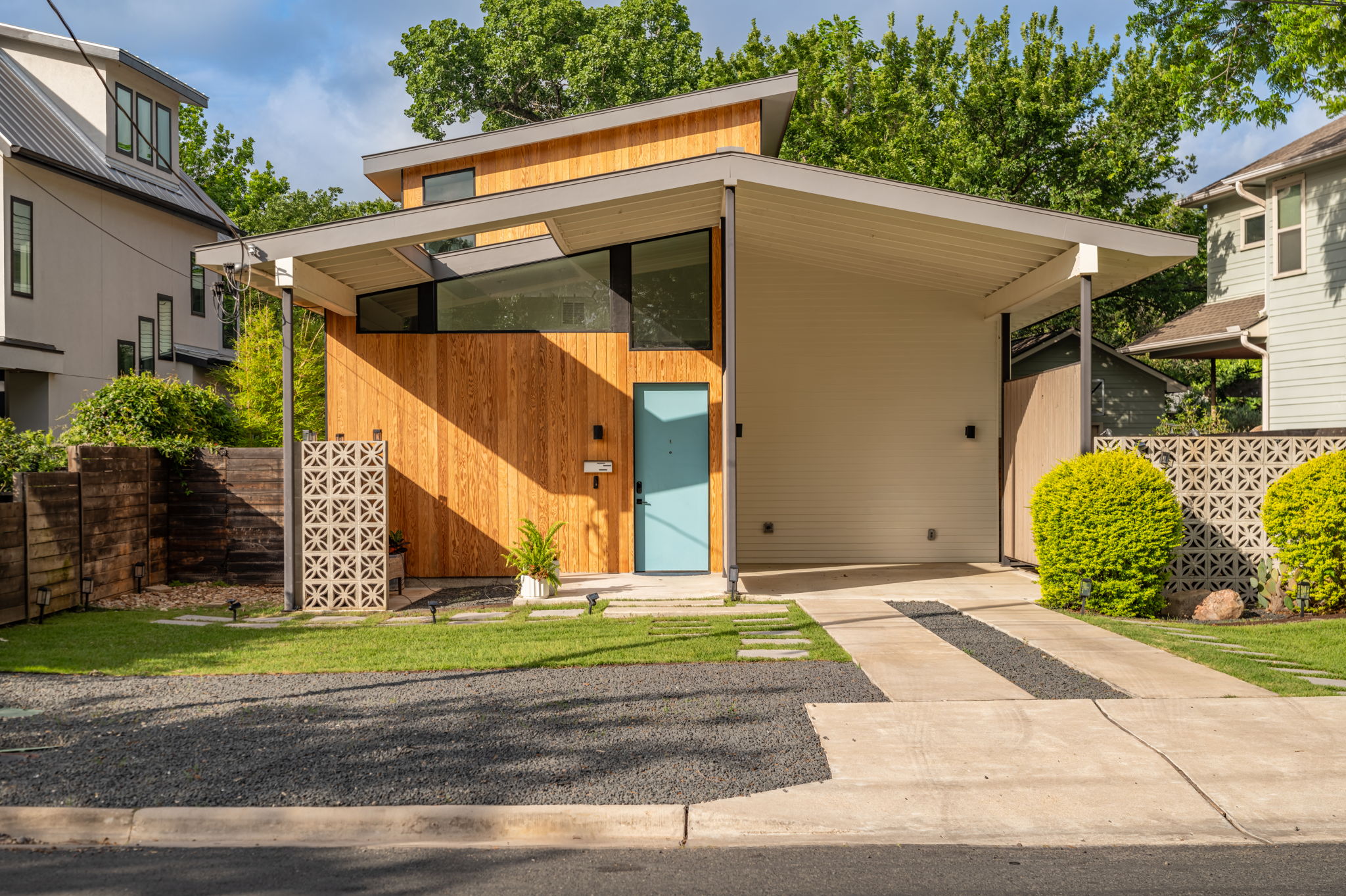 1811 Collier Street Austin, TX 78704 - Photo 2 of 40 Contemporary home exterior featuring a striking sloped roofline and a combination of natural wood siding and light-colored panels