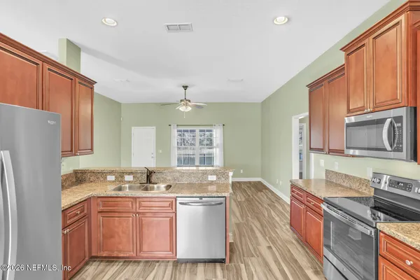 a kitchen with stainless steel appliances granite countertop a sink stove and refrigerator