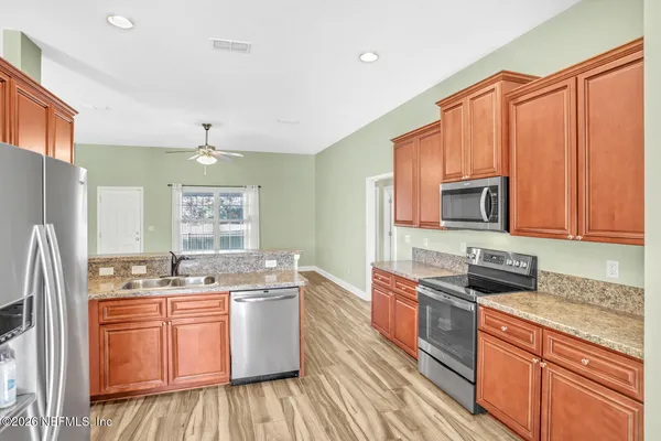 a kitchen with stainless steel appliances granite countertop a sink stove and refrigerator