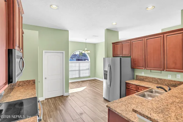 a kitchen with stainless steel appliances granite countertop a refrigerator and a stove