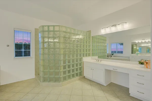 a bathroom with a sink mirror and a shower