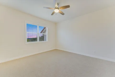 an empty room with a window and a ceiling fan