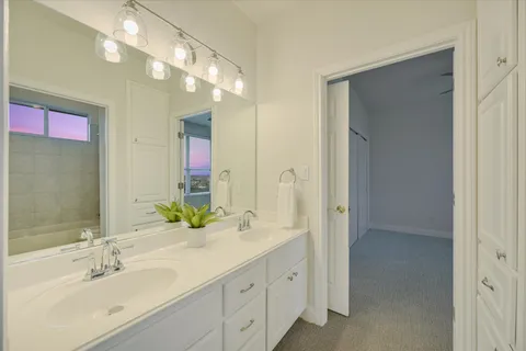 a bathroom with double vanity sink and a mirror
