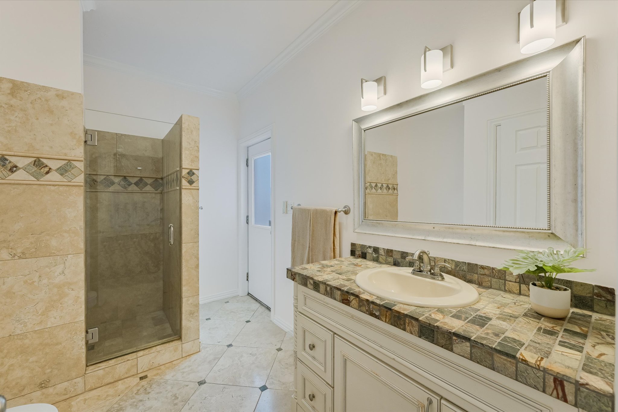 4319 Rum Runner Road Austin, TX 78734 - Photo 34 of 40 a bathroom with a granite countertop sink a mirror and shower