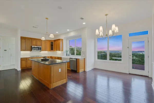 an open kitchen with wooden floor and large cabinets