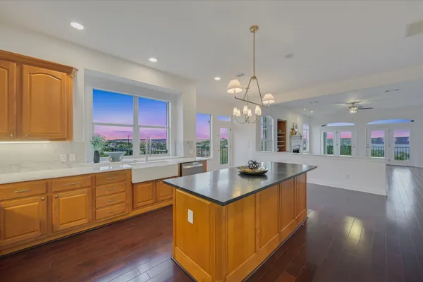 a kitchen with stainless steel appliances granite countertop a sink a stove and a wooden floors