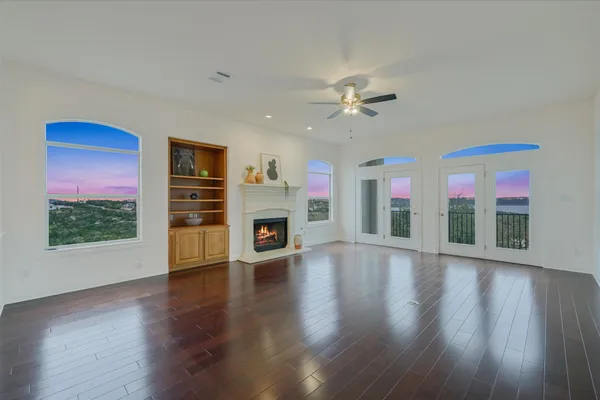 a view of a livingroom with furniture chandelier fan and wooden floor