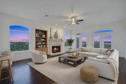 a living room with furniture a fireplace and a large window