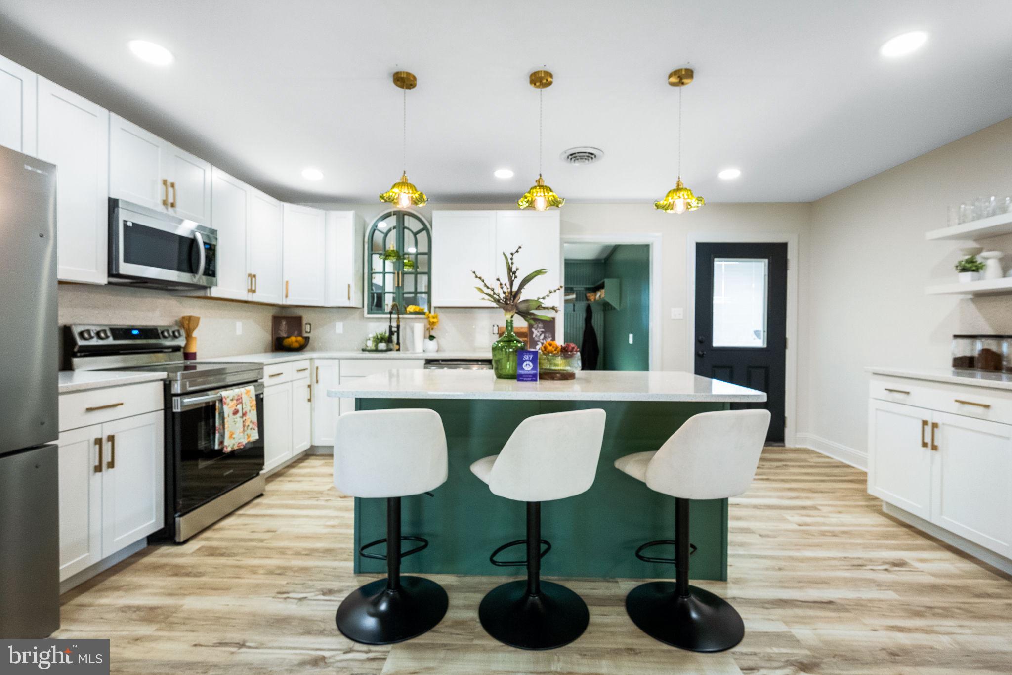 a kitchen with stainless steel appliances a dining table chairs microwave and sink