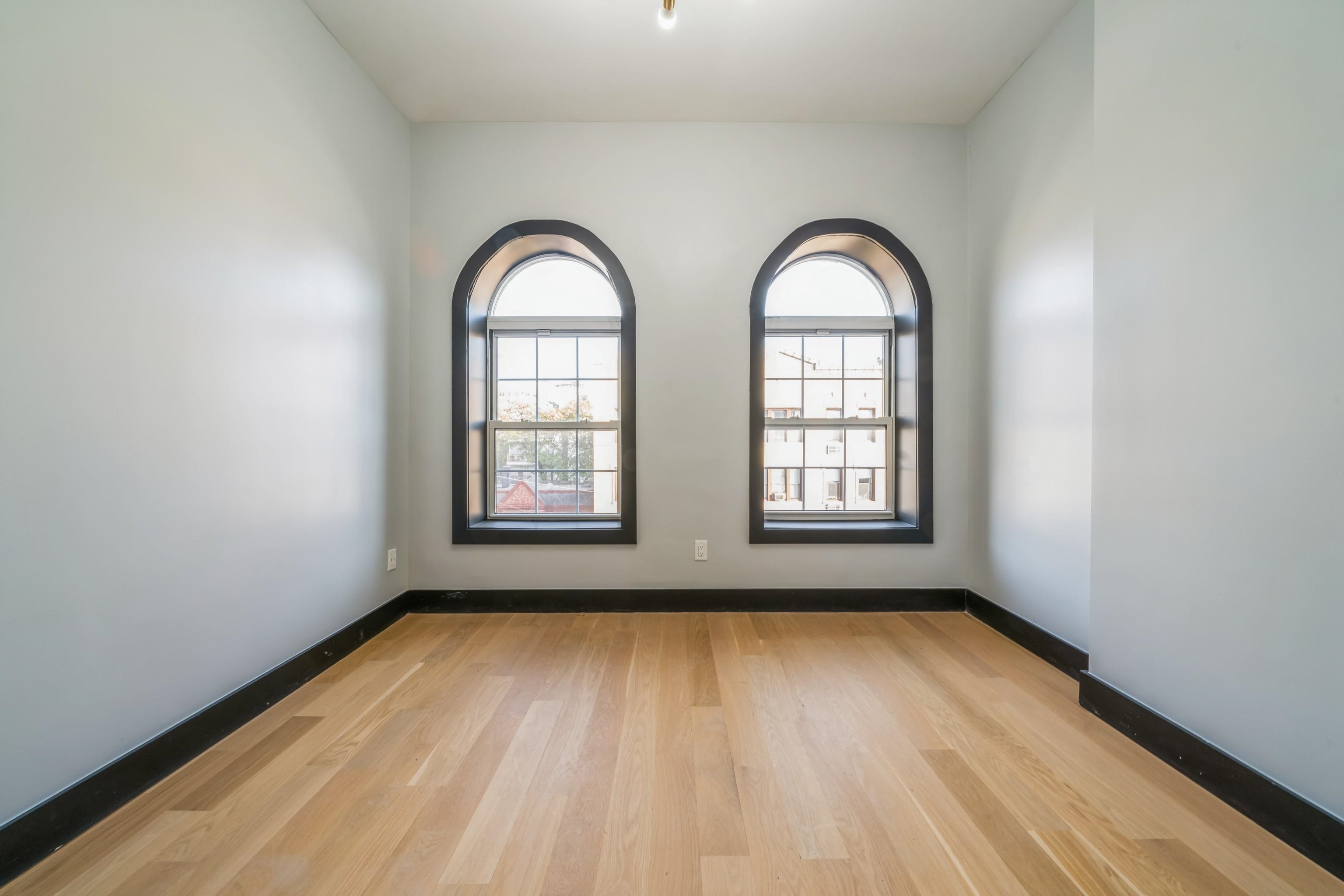 a view of a room with wooden floors and window