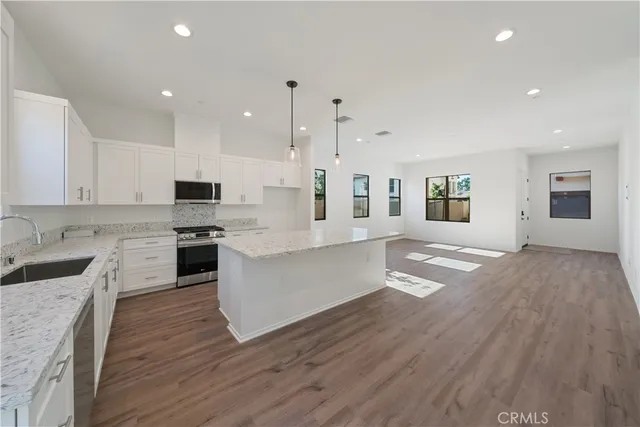 a large kitchen with cabinets wooden floor and stainless steel appliances