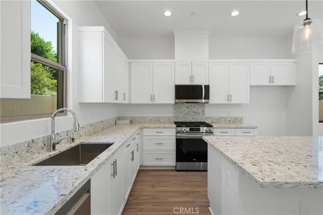a kitchen with a sink stove top oven and cabinets
