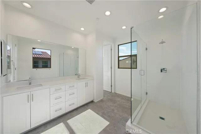 a bathroom with a double vanity sink toilet and shower