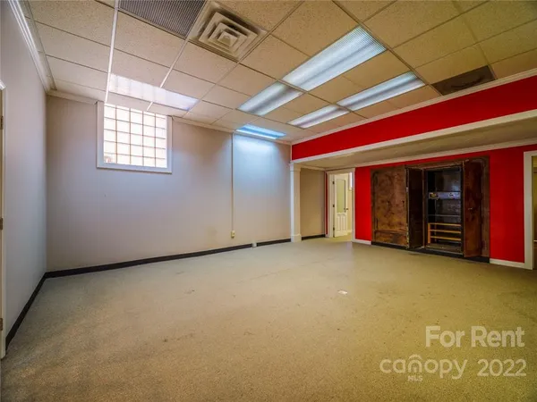 a view of an empty room with closet and a window