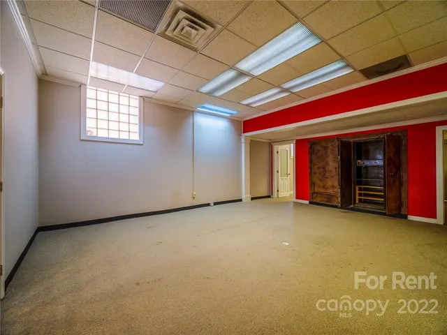 a view of an empty room with closet and a window