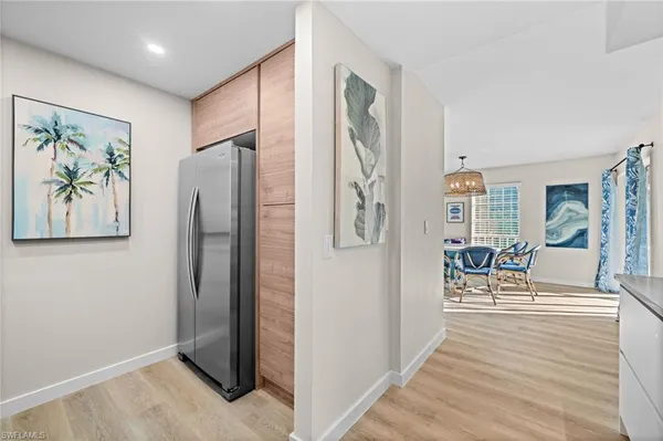 a view of a hallway with wooden floor and a living room