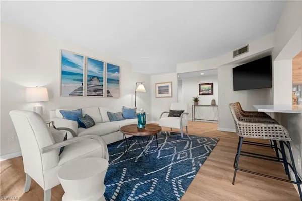 a living room with furniture a flat screen tv and a window