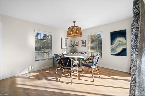 a view of a dining room with furniture a chandelier and wooden floor